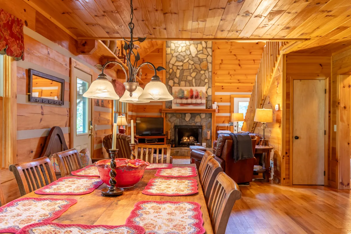 A cozy living room features a comfortable sectional sofa, a wooden coffee table, and a rustic stone fireplace. The space invites families to gather for game nights, storytelling, or simply unwinding in comfort. Warm lighting and homey touches reinforce the family-oriented atmosphere.